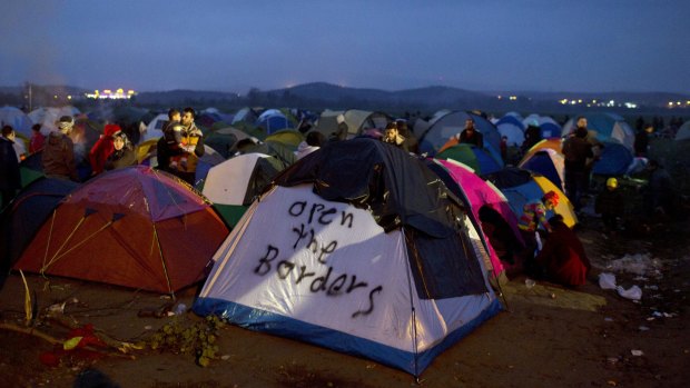Refugees and migrants near their tents near the Greek-Macedonian border, in Idomeni, on Monday.