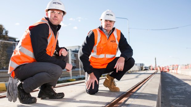 The test track slabs for the light rail have been laid. From left, Mark Jones deputy project director, and Glenn Stockton Canberra Metro CEO, next to the epoxy compound that encases the rail to both secure the rail in the track slot and as part of the stray current management system.