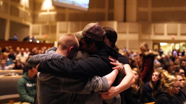 Members of the community pray before the start of the Kalamazoo community prayer service for the shooting victims on Sunday.