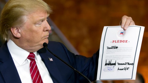 Republican presidential candidate Donald Trump looks at a signed pledge during a news conference in the Trump Tower on Thursday.