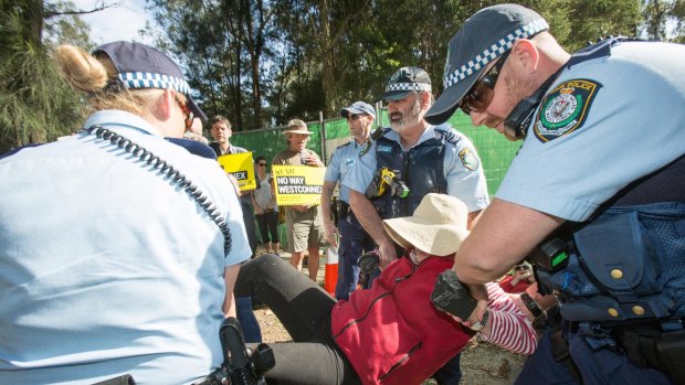 Protesters blocked construction workers for about an hour before they were forcibly removed by police.