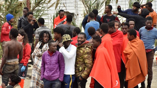 Migrants stand together after storming a fence to enter the Ceuta on December 9.