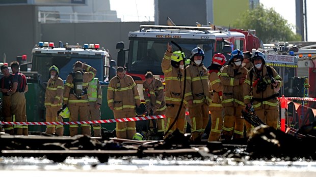 Firefighters at the scene of the plane crash at the Essendon DFO. 