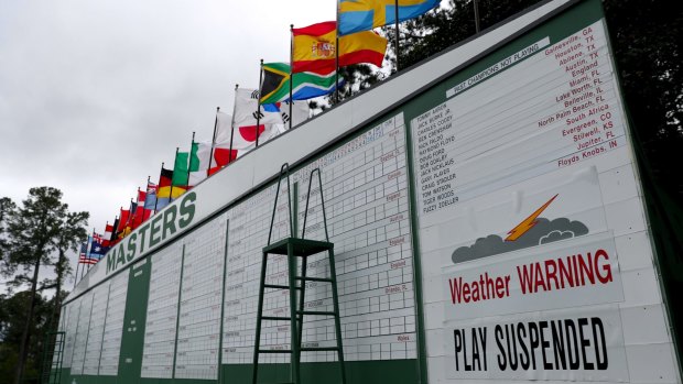 A sign on a leaderboard indicates that play is suspended due to inclement weather at Augusta National Golf Club.