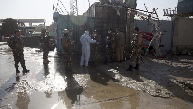 Afghan security personnel inspect the site of a suicide attack in Kabul in June. The insurgents have recently made inroads into Helmand Province, killing Afghan soldiers there.