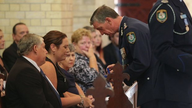 Senior Constable Margaret King is handed three medals by Commissioner Andrew Scipione posthumously awarded to her husband Geoffrey Richardson.