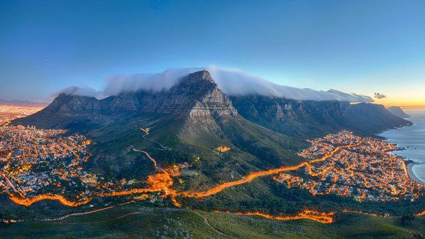 Table Mountain covered by its typical cloud table cloth and the twelve Apostles. Below on the left you can see Cape Town and the beautiful Camps Bay on the right. Taken right after sunset. str16cover-health Credit: iStock