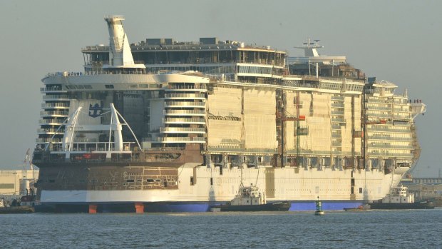 Mammoth in the making ... Cruise liner Harmony of the Seas is towed by tug boats into its new moorings at the STX Shipyards in Saint-Nazaire.