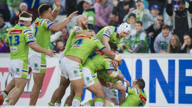 Eureka: The Raiders swamp Jordan Rapana after his golden-point try.