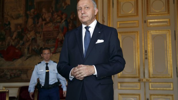 French Foreign Affairs Minister Laurent Fabius arrives to talk to the media. The French have released a draft text of a climate deal.