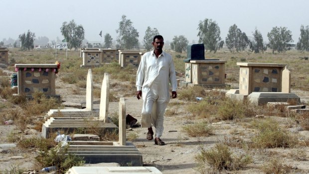 A man walks among the graves at a cemetery in Kerbala. Many of the gravestones remain blank as those buried cannot be identified.