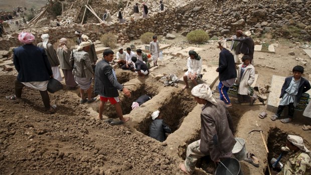 People dig graves for the victims of an air strike in Okash village near Sanaa.