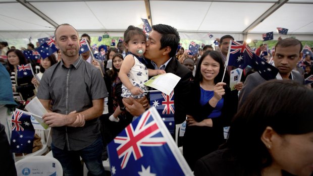 Michael Bulanan giving his two-year-old daughter a kiss while his wife Rachelle Bulanan watches on at the Australia Day ceremony in Sunshine.