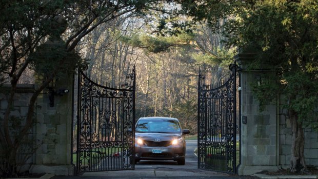 Cars with diplomatic plates drive out of a compound near Glen Cove on Long Island on December 30, after the US expelled dozens of Russian diplomats.