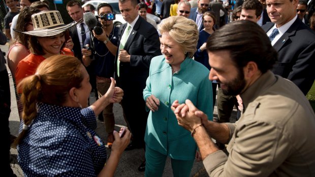 Democratic presidential candidate Hillary Clinton, accompanied by actor Jencarlos Canela, greets people outside an early voting centre in West Miami, Florida.