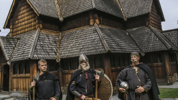 Anders Kvale Rue, centre, who leads a group of amateur Viking enthusiasts, with his friends Oystein Rivrud, right, and Rivrud's son Nils, left, in front of a 13th century church in Heddal, Norway.