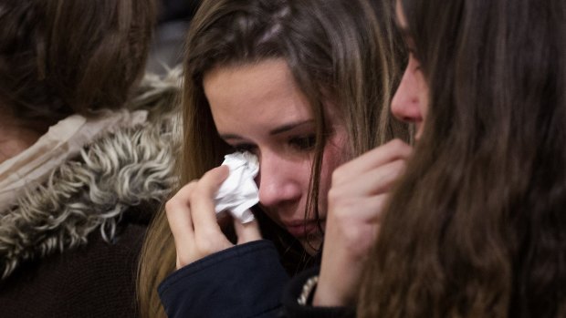 A friend of the German students from the crashed plane wipes away tears during a mass in Llinars del Valles, near Barcelona.
