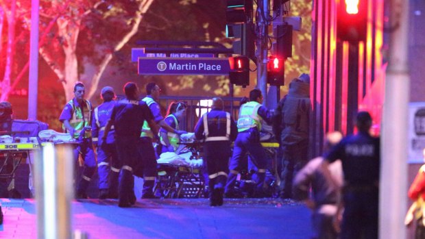Ambulance officers move into the Lindt Chocolate Cafe as the siege comes to a dramatic end.