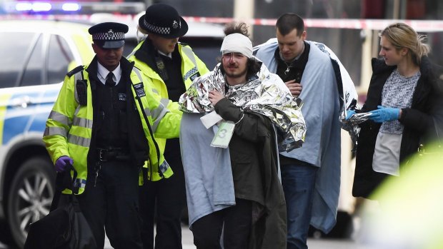 Walking wounded: A man is treated by emergency services near Westminster Bridge.