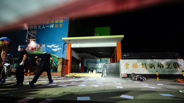 Investigators work at the scene of an explosion outside a kindergarten in Fengxian County.