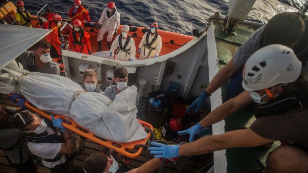 Aid workers of Proactiva Open Arms recover dead bodies of sub-Saharan migrants inside a rubber boat in the Mediterranean Sea.