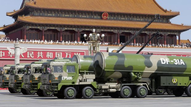 A parade of military power in Beijing in September.  Military vehicles carrying DF-31A long-range missiles drive past the Tiananmen Gate.