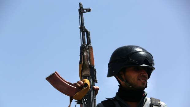 An Afghan security policeman stands guard near the site of a truck bombing earlier this year.