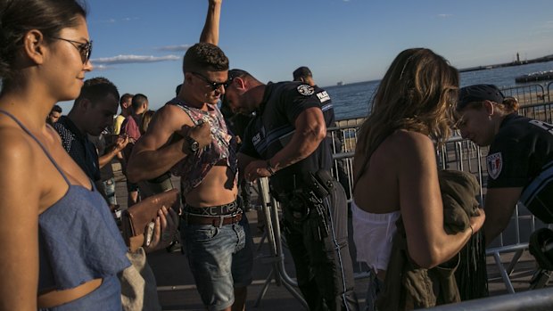 Members of the public have their belongings checked before entering a dance zone on the promenade in Cannes, France. 