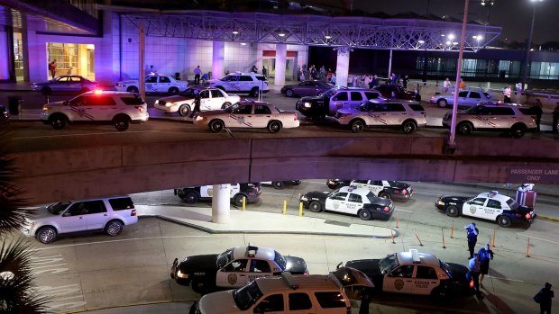 Dozens of police vehicles surround the entrance to New Orleans Louis Armstrong International Airport after a machete-wielding man was shot by a TSA employee.