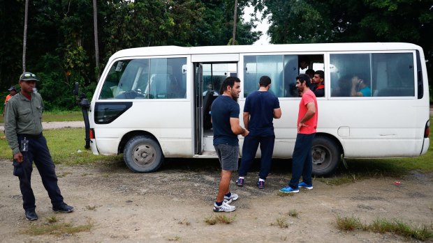 Asylum seekers return to the bus after a visit into town on Manus Island in April.