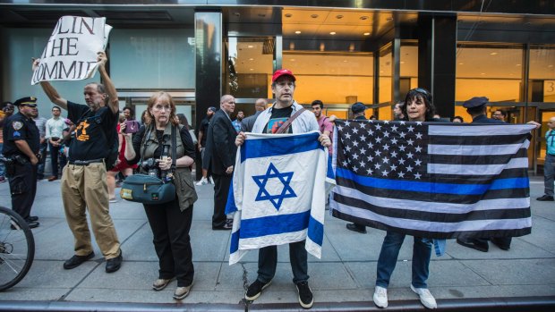 August 2017: After gridiron footballer Colin Kaepernick begins protesting the slaying of black youth by police, a counter-protest outside the National Football League's headquarters in Park Avenue, Manhattan, condemns "Colin the Commie" and displays the Israeli flag and the "Thin Blue Line" flag in support of police.