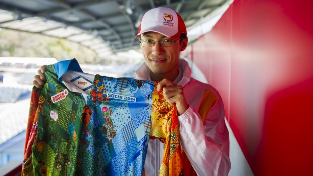 Chen Tang, 24, shows off his volunteer uniforms for next year's Asian Cup, and the 2014 Sochi Winter Olympics.
