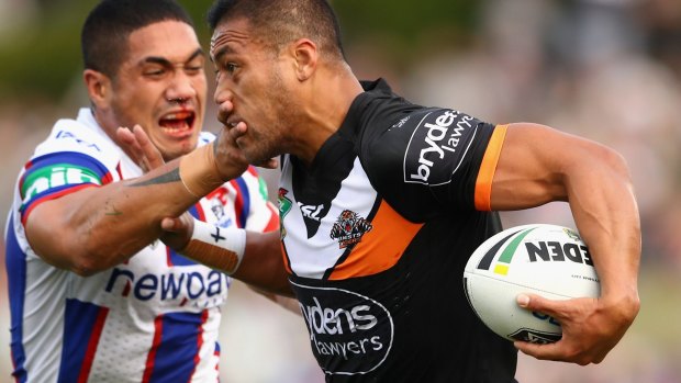 Keeping the defence at arm's length: Tim Simona puts on a big fend.