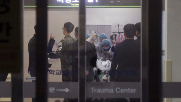 A South Korean army soldier, second from left, is seen as doctors operate on an unidentified North Korean soldier at a hospital in Suwon, South Korea. 