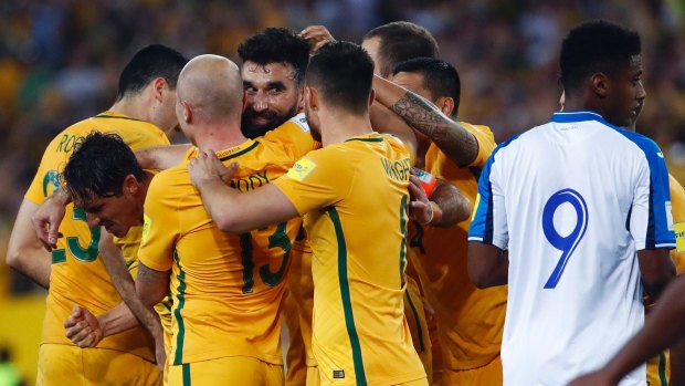 Australia's Mile Jedinak (centre) is congratulated by teammates after scoring.