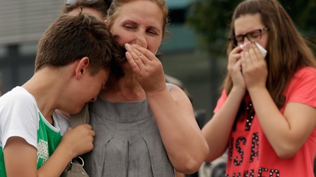 People mourn near the crime scene. 