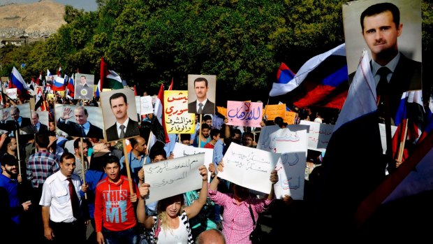 Syrians holding photos of Syrian President Bashar al-Assad and Russian President Vladimir Putin, during a rally to thank Moscow for its intervention in Syria, in front of the Russian embassy in Damascus.