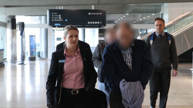 The two suspects, with their faces obscured here, arrive at Sydney Airport, escorted by police.