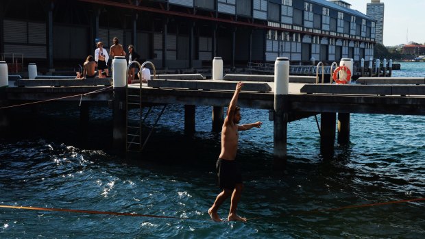 Finding a way to cool off: Slackliners cross the harbour between Pier 1 and 2 in Dawes Point.