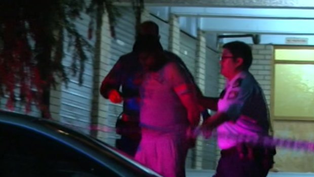 Shahab Ahmed, 33, is lead away by police after his wife was stabbed in Parramatta.