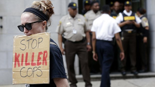 A protester displays a sign outside the courthouse in Baltimore.