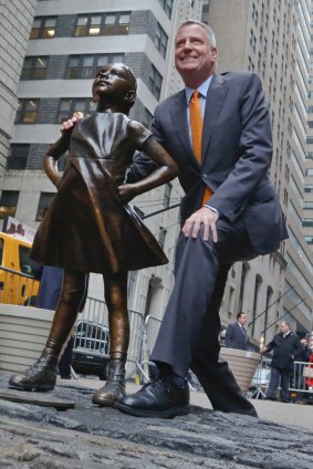 New York Mayor Bill de Blasio poses with the "Fearless Girl" statue.