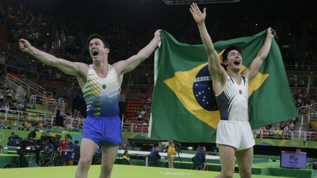 Local heroes: Brazil's Arthur Mariano, right, and Diego Hypolito share the limelight after winning bronze and silver in the men's floor final at the gymnastics.