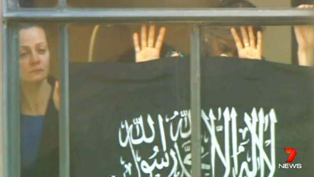 Hostage Marcia Mikhael against the window of the Lindt cafe during the siege.