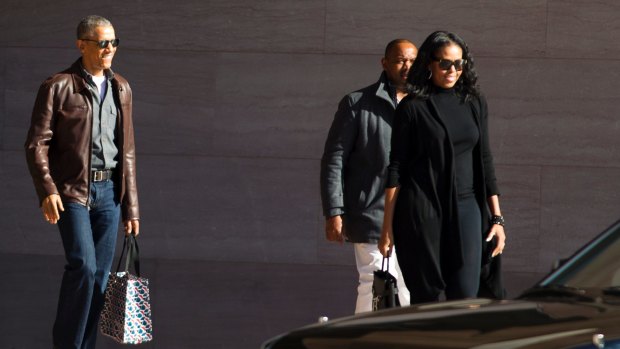 Former President Barack Obama accompanied by former first lady Michelle Obama leaves the National Gallery of Art in Washington.
