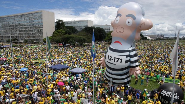 Thousands of demonstrators demand the impeachment of Brazil's President Dilma Rousseff during a rally in Brasilia on Sunday where a large inflatable doll depicts former president Luiz Inacio Lula da Silva in prison garb.