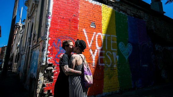  A couple embrace to celebrate the "yes" verdict of Australia's postal vote on same-sex marriage in Newtown.