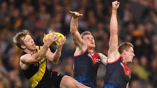 Jack Riewoldt of the Tigers marks over the top of Tom McDonald and Sam Frost of the Demons.