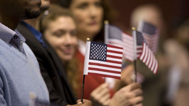 People hold miniature American flags during a naturalization ceremony in San Diego, California, US.