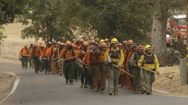 A California Department of Corrections and Rehabilitation inmate work crew walks on the way to battle a fire on Sunday.